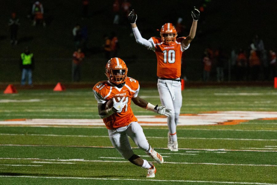 Quarterback Billy Osborn (R) celebrates a carry by Dhante Johnson (L)