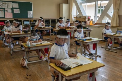 NIKKO, JAPAN - JUNE 03: Children wearing plastic face visors sit in class at Kinugawa Elementary School on June 3, 2020 in Nikko, Japan. Schools in Japan reopened this week after being forced to close earlier in the year by the Covid-19 coronavirus outbreak. Safety measures have been implemented throughout the country, including social distancing in classrooms, use of hand sanitiser, face masks and, in some cases, plastic face visors for students and teachers. (Photo by Carl Court/Getty Images)