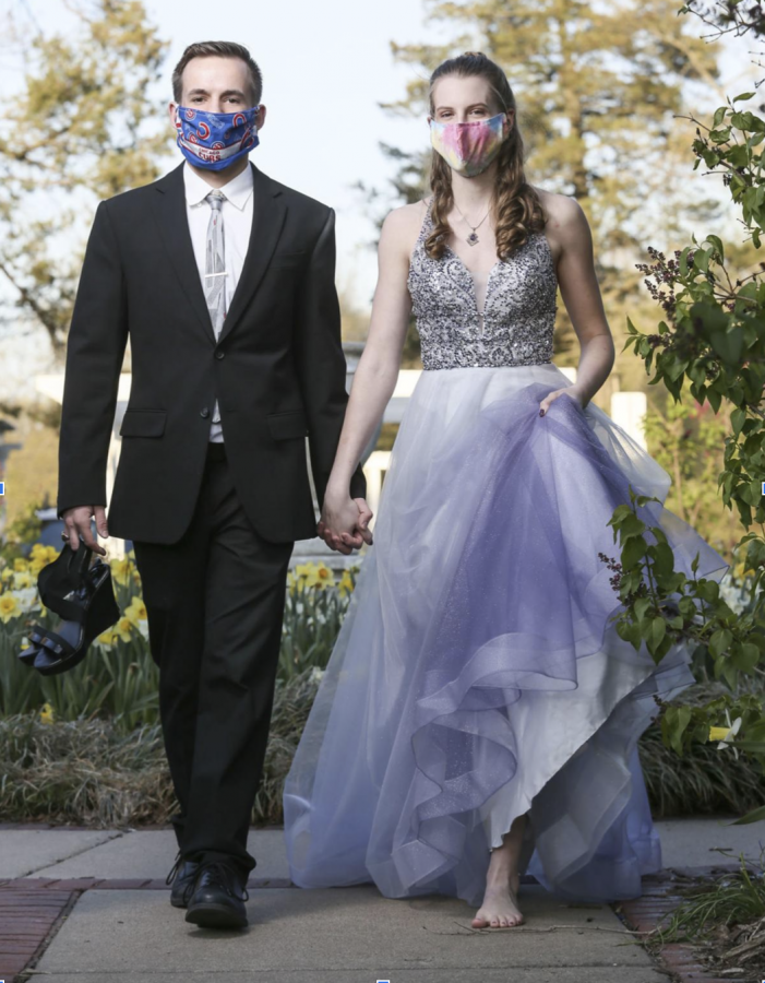 Two people wearing formal clothing and face masks. 