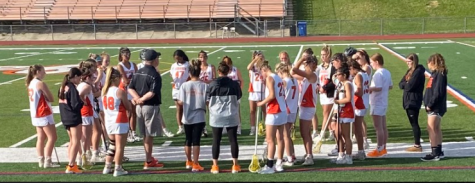 Cherokee girls lacrosse coaches talk to the team before a play.